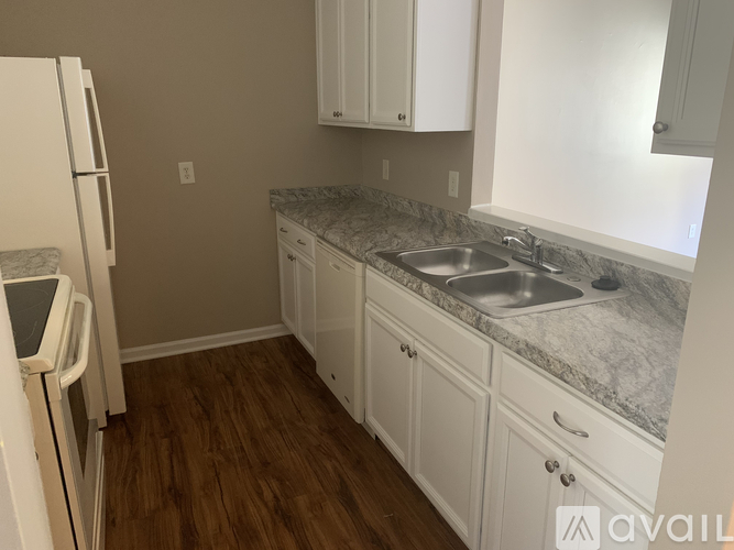 A kitchen with white cabinets and a marble countertop.