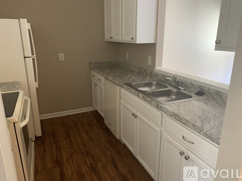 A kitchen with white cabinets and a marble countertop.