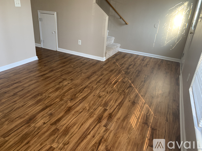 A room with wooden flooring and a staircase.