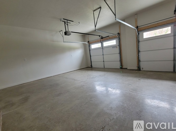 A spacious garage with a concrete floor and white walls.