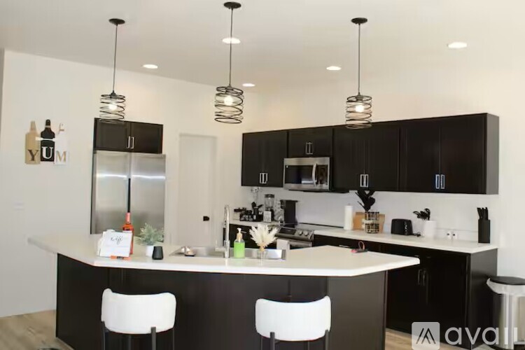 A modern kitchen with black cabinets and white countertops.