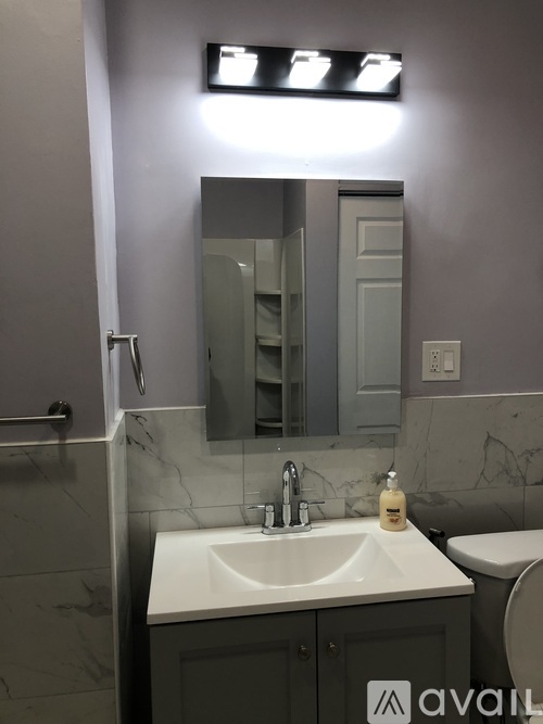 A bathroom with a sink, mirror, and toilet.