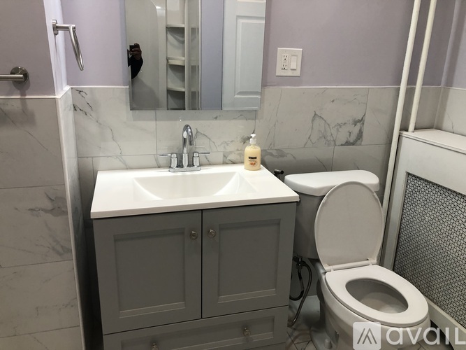 A bathroom with a sink, toilet, and mirror.
