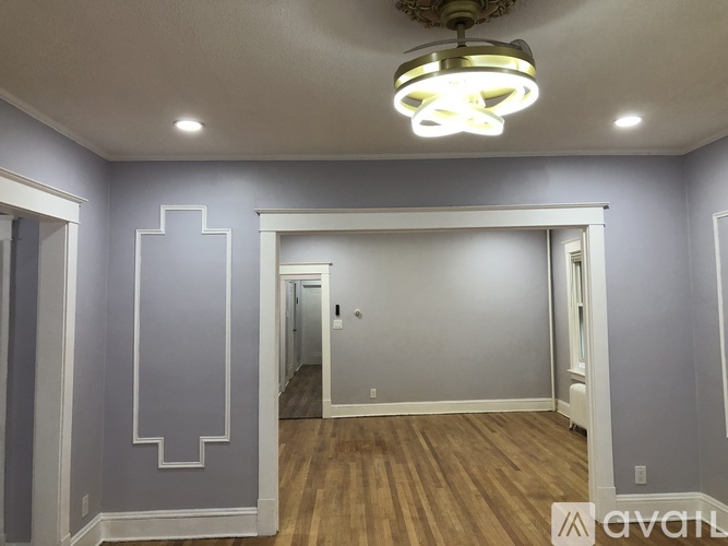 A room with a grey wall and a wooden floor.