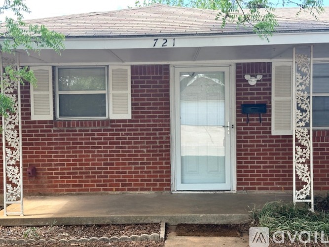 A red brick house with white window frames and a white door.