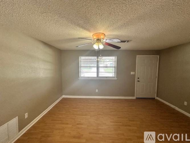 A room with a ceiling fan and a window.
