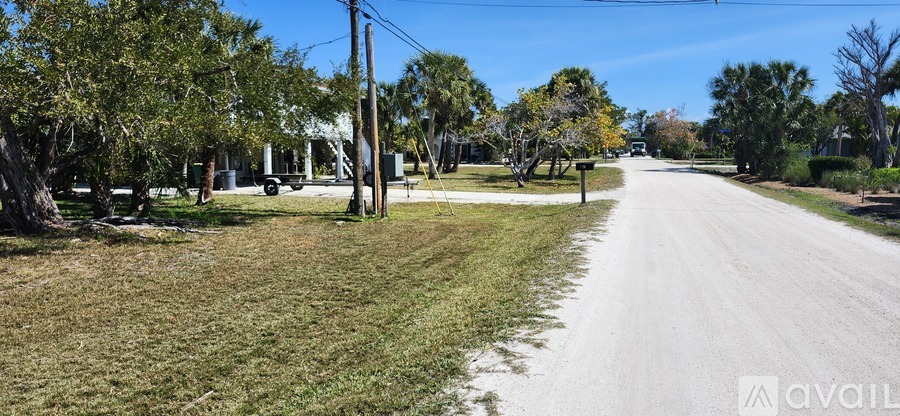 A street with a grassy area on the side and a sign that says "available".