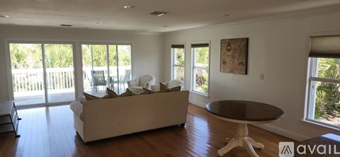 A living room with a couch, a table, and a painting on the wall.