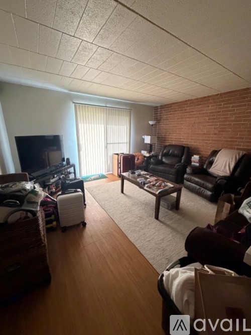 A living room with a brick wall and a flat screen TV.
