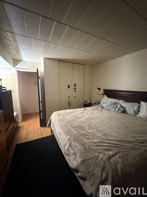 A bedroom with a bed, dresser, and wardrobe.