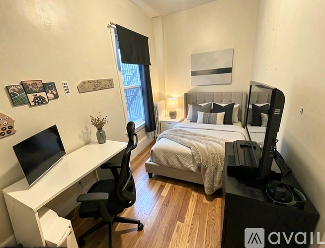 A bedroom with a bed, desk, and chair.