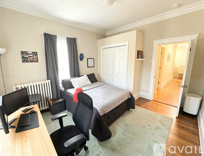 A bedroom with a bed, desk, and chair.