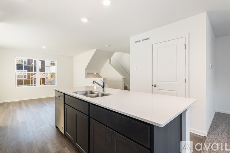 A kitchen with a white counter top and black cabinets.