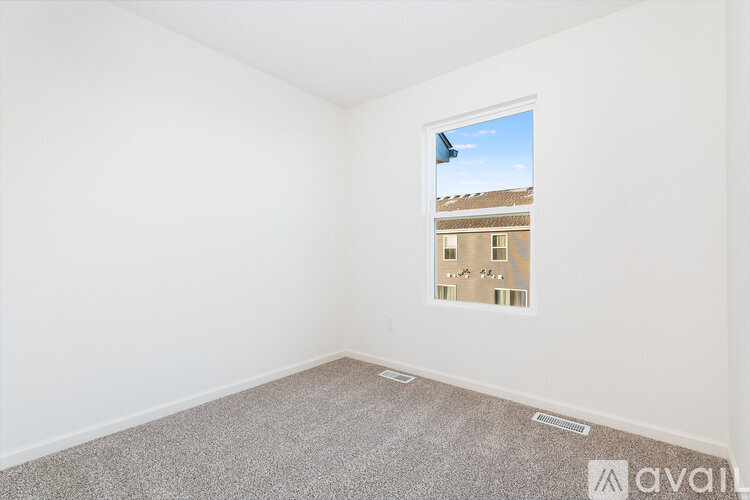 A room with a window showing a building outside.