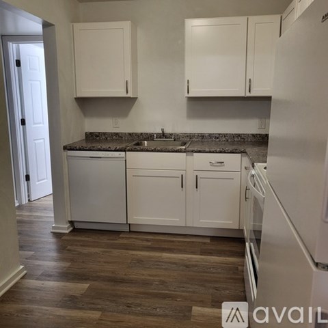 A kitchen with white cabinets and a granite countertop.