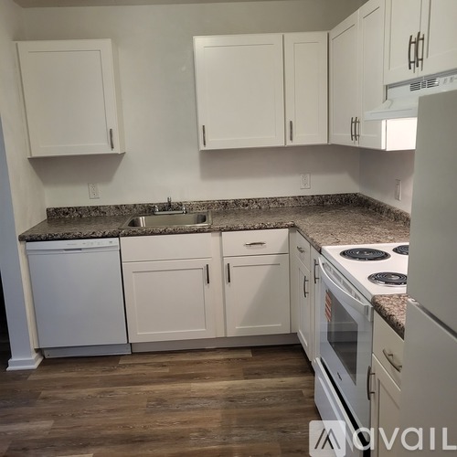 A kitchen with white cabinets and a granite countertop.