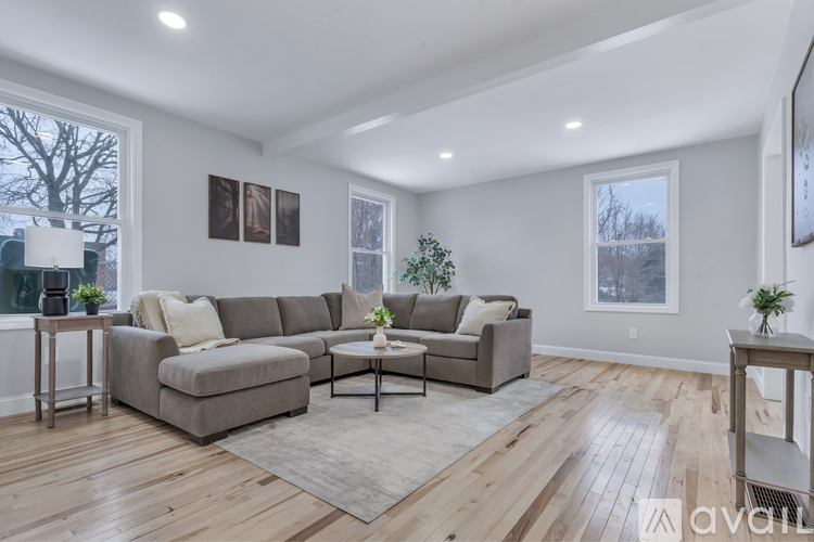 A living room with a grey sofa set and a wooden floor.