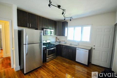 A kitchen with a refrigerator, oven, and microwave.