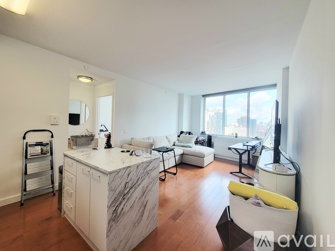 A living room with a white kitchen island and a yellow chair.
