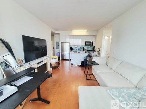 A living room with a white couch and a black desk.