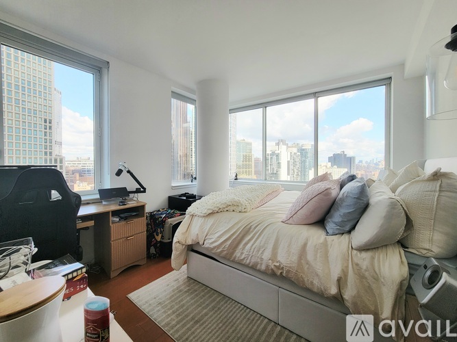 A bedroom with a large bed and a desk with a computer.