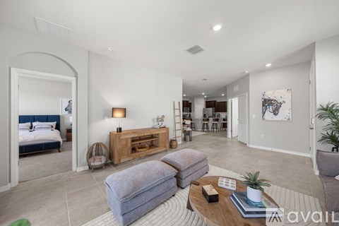 A spacious living room with a grey sofa and a wooden coffee table.