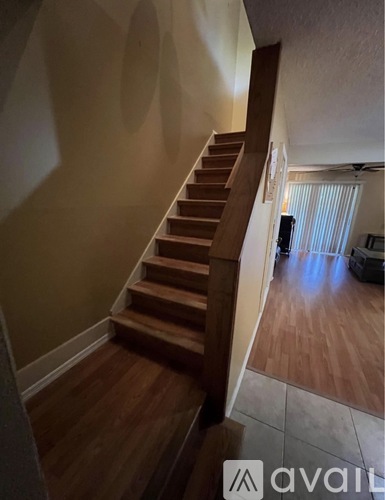 A wooden staircase leads to a living room with a television.