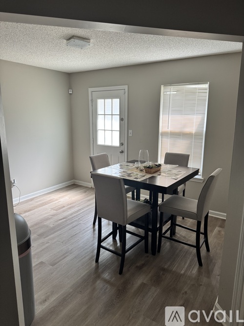 A dining room with a table set for four.