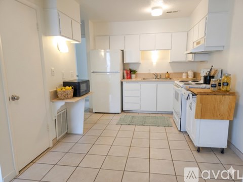 A kitchen with white cabinets and appliances.
