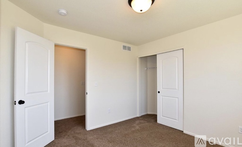 A room with two doors and a carpeted floor.