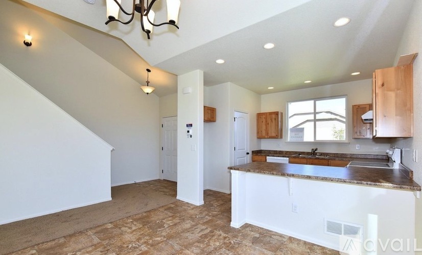 A kitchen with a counter top and a chandelier.