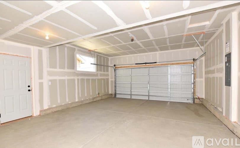 A spacious garage with a closed white door and a window.