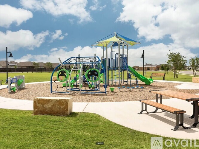 A playground with a green slide and a blue and yellow structure.