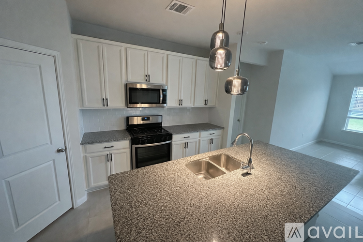 A kitchen with granite countertops and white cabinets.
