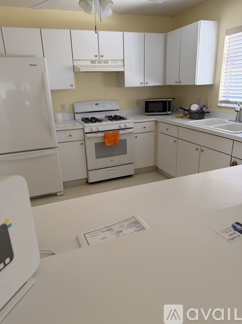 A white kitchen with a fridge, oven, microwave and dishwasher.