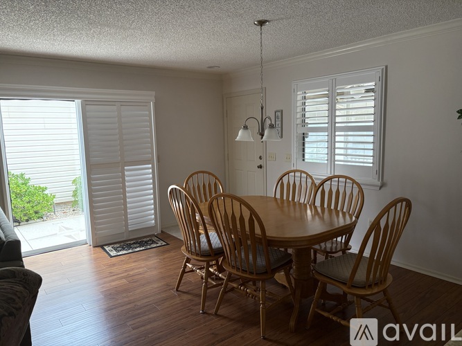 A dining room with a wooden table and chairs.
