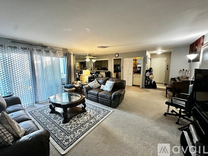 A living room with a black leather couch and a coffee table.