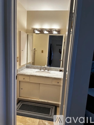 A bathroom with a sink, mirror, and lights.