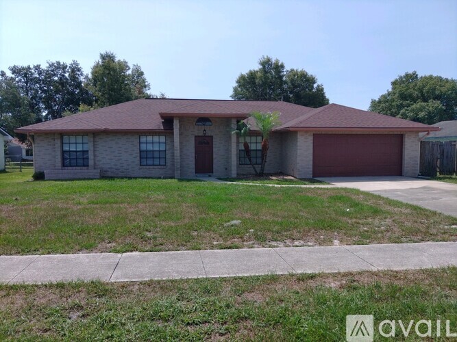 A house with a red roof and a garage door is for sale.