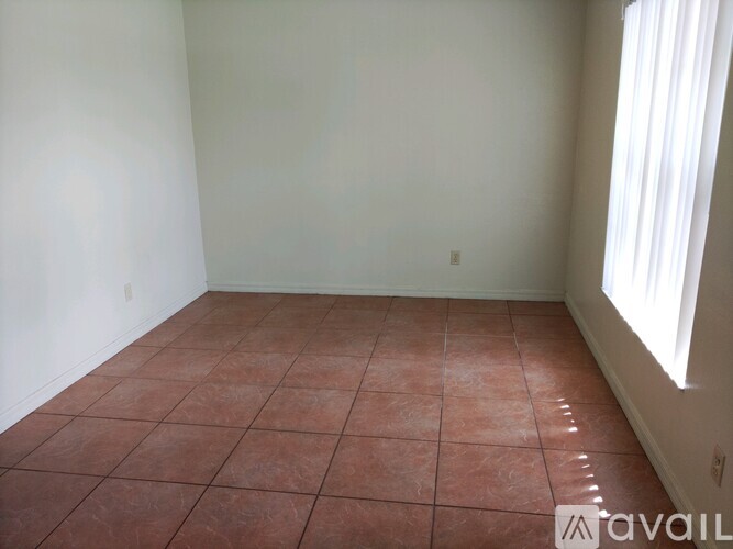 A room with a tiled floor and a window letting in light.