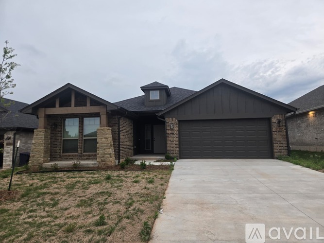 A modern house with a black garage door is available for purchase.