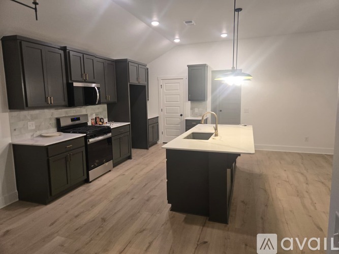 A kitchen with black cabinets and a white countertop.