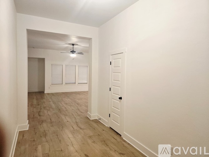 A room with a ceiling fan and a door.