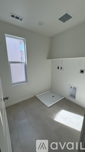 A bathroom with a window and a tiled floor.