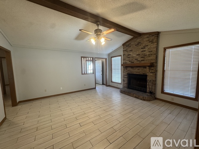 A living room with a fireplace and a ceiling fan.