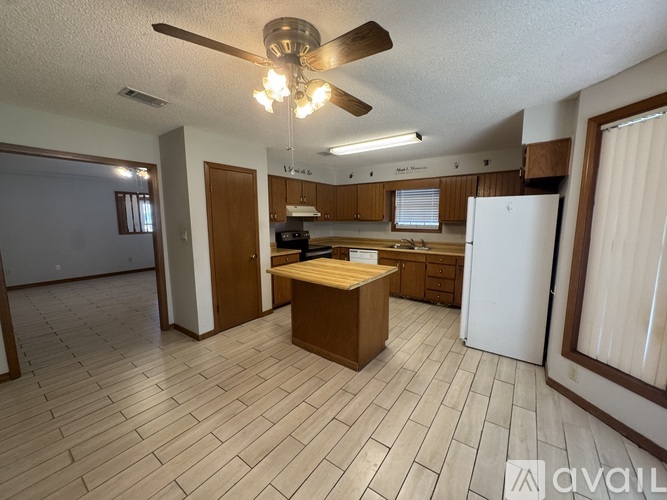 A kitchen with a white refrigerator and wooden cabinets.