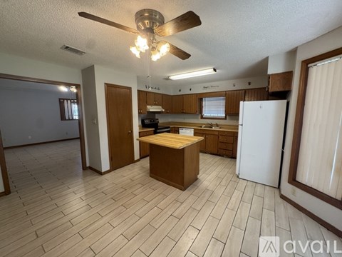 A kitchen with a white refrigerator and wooden cabinets.