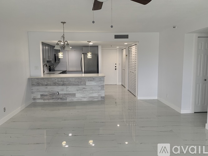 A spacious room with a stone countertop and a ceiling fan.