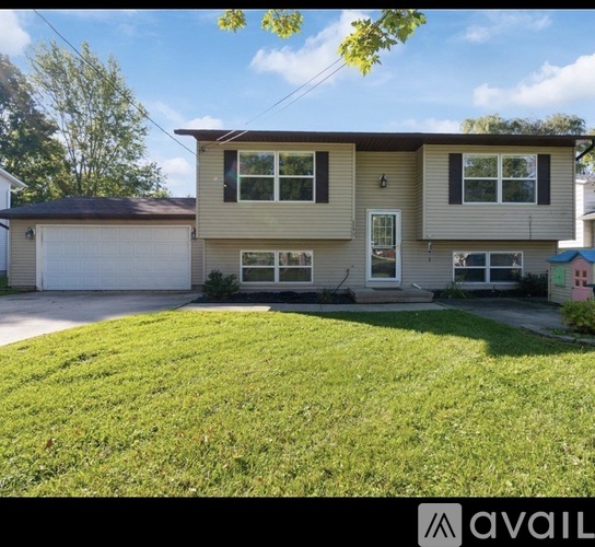 A two-story house with a garage and a driveway.