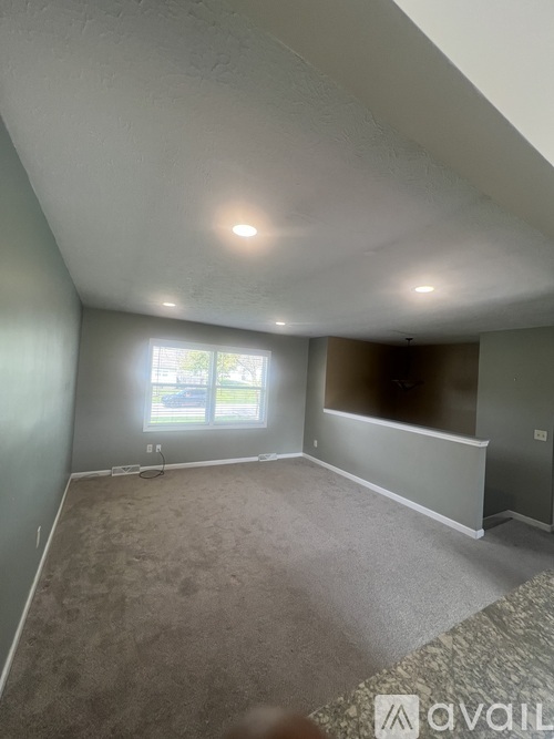 A room with a window and carpeted floor.